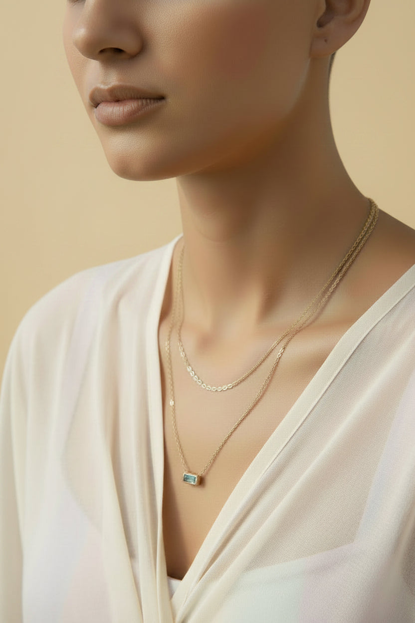 Gold layered necklace with blue zirconia pendant