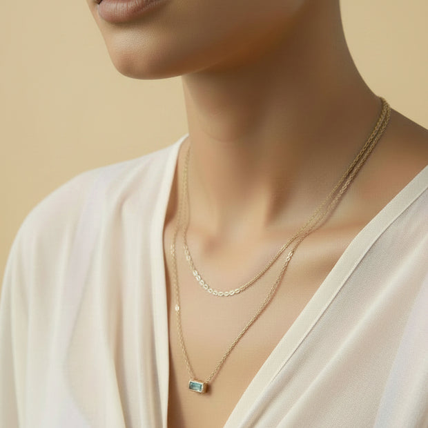 Gold layered necklace with blue zirconia pendant